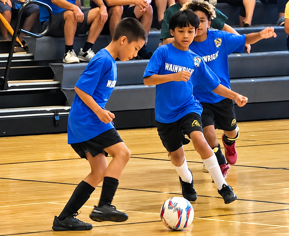 Youth soccer players competing on the gym floor