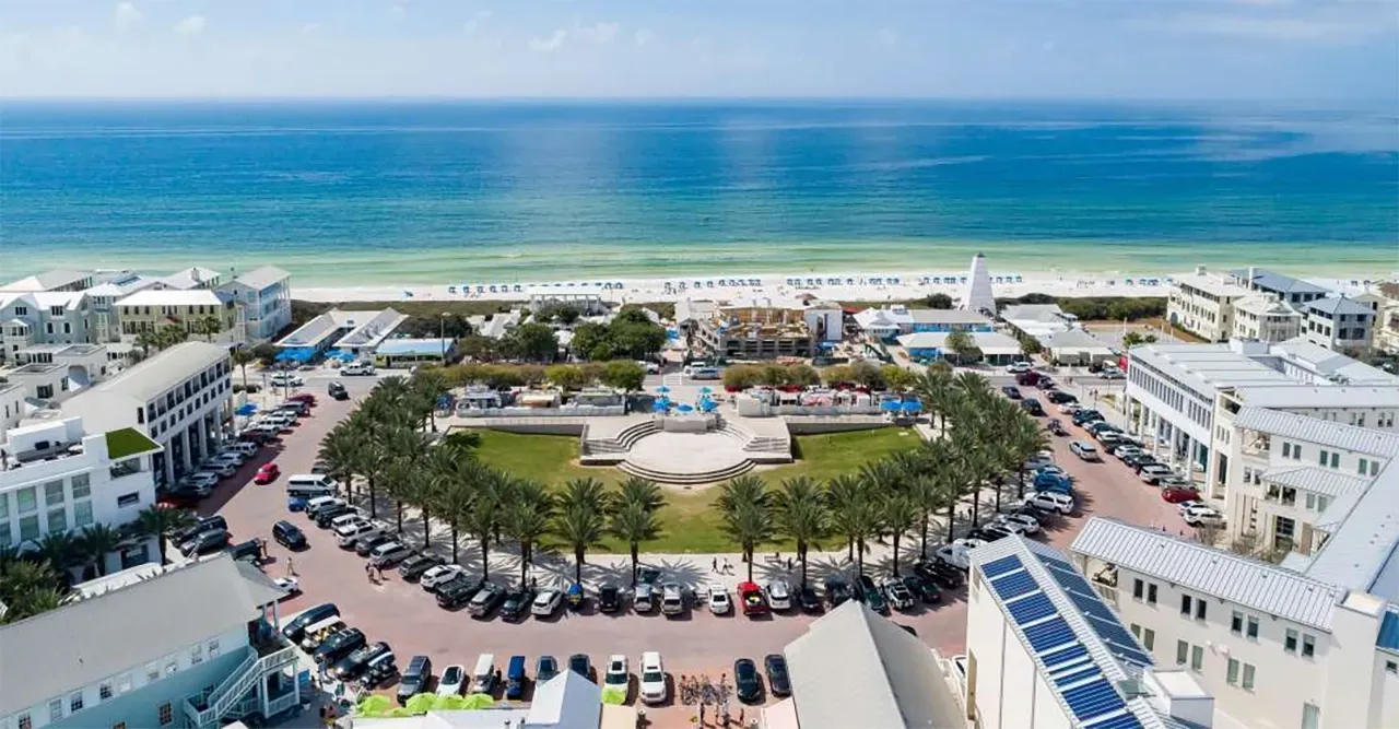 An aerial view of a city with a lot of cars parked in front of a beach.