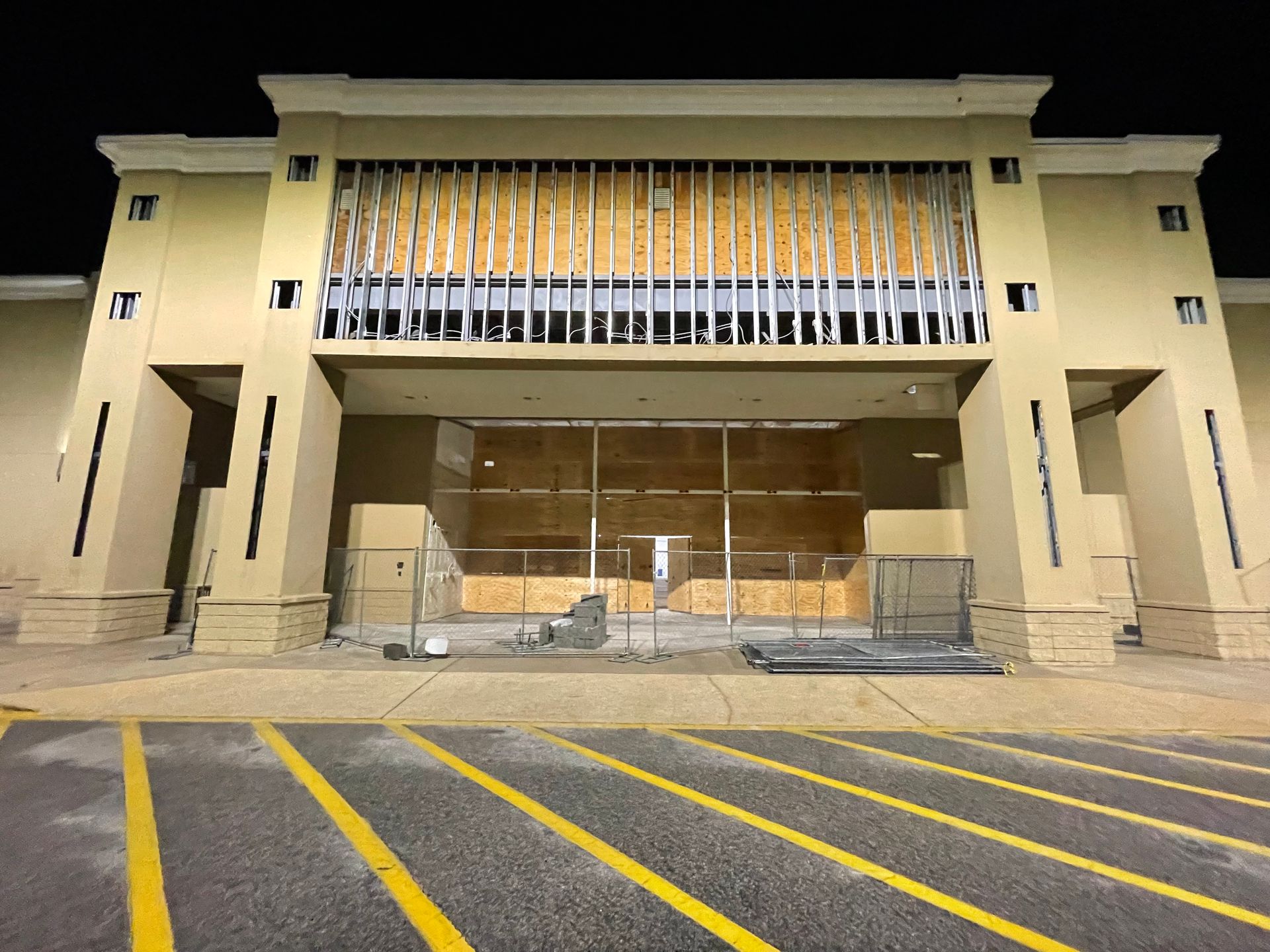A large building under construction with a parking lot in front of it