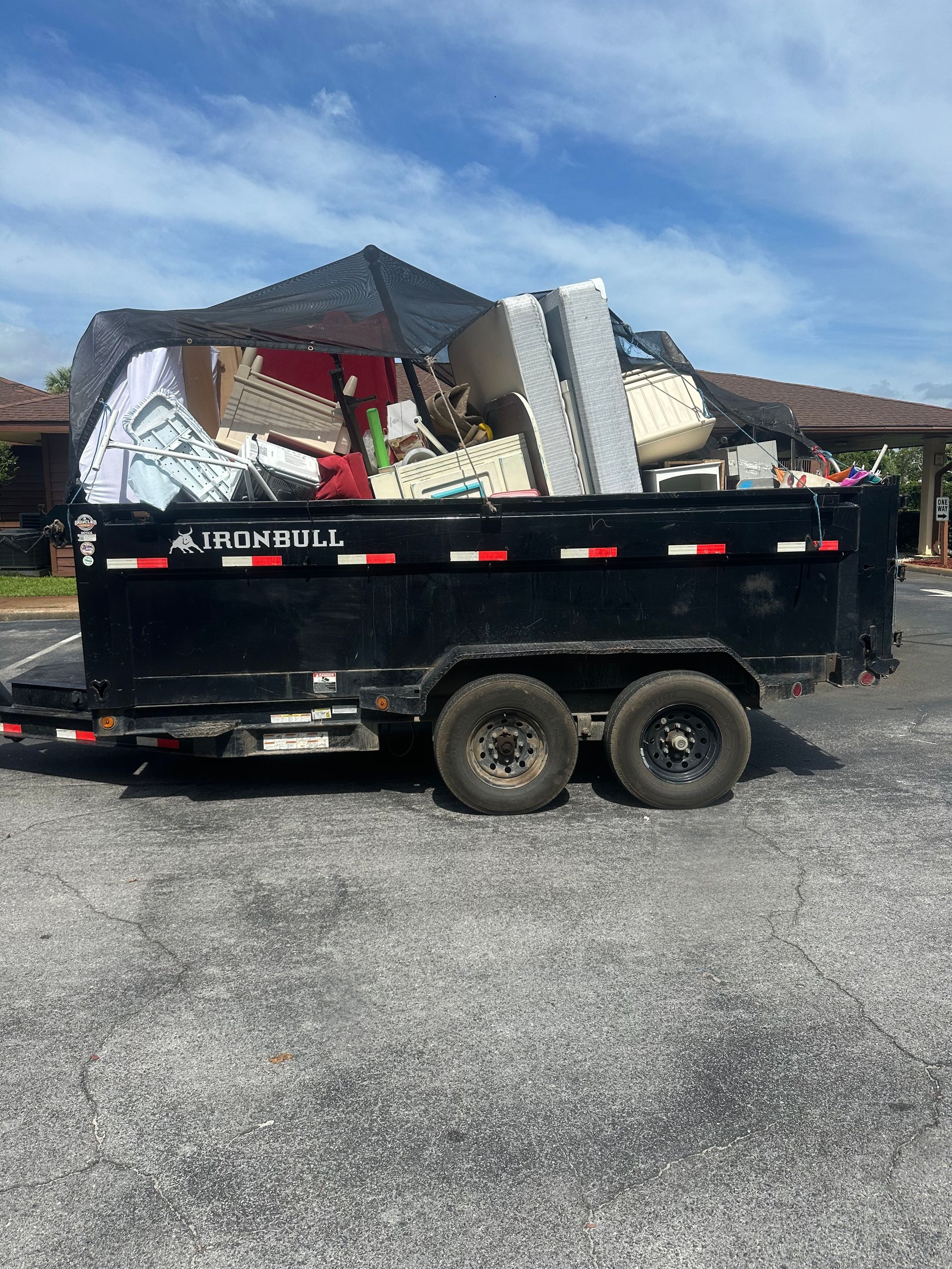 Dump trailer loaded with old mattresses and furniture, mattress and furniture removal for Laguna Beach vacation rentals, FL