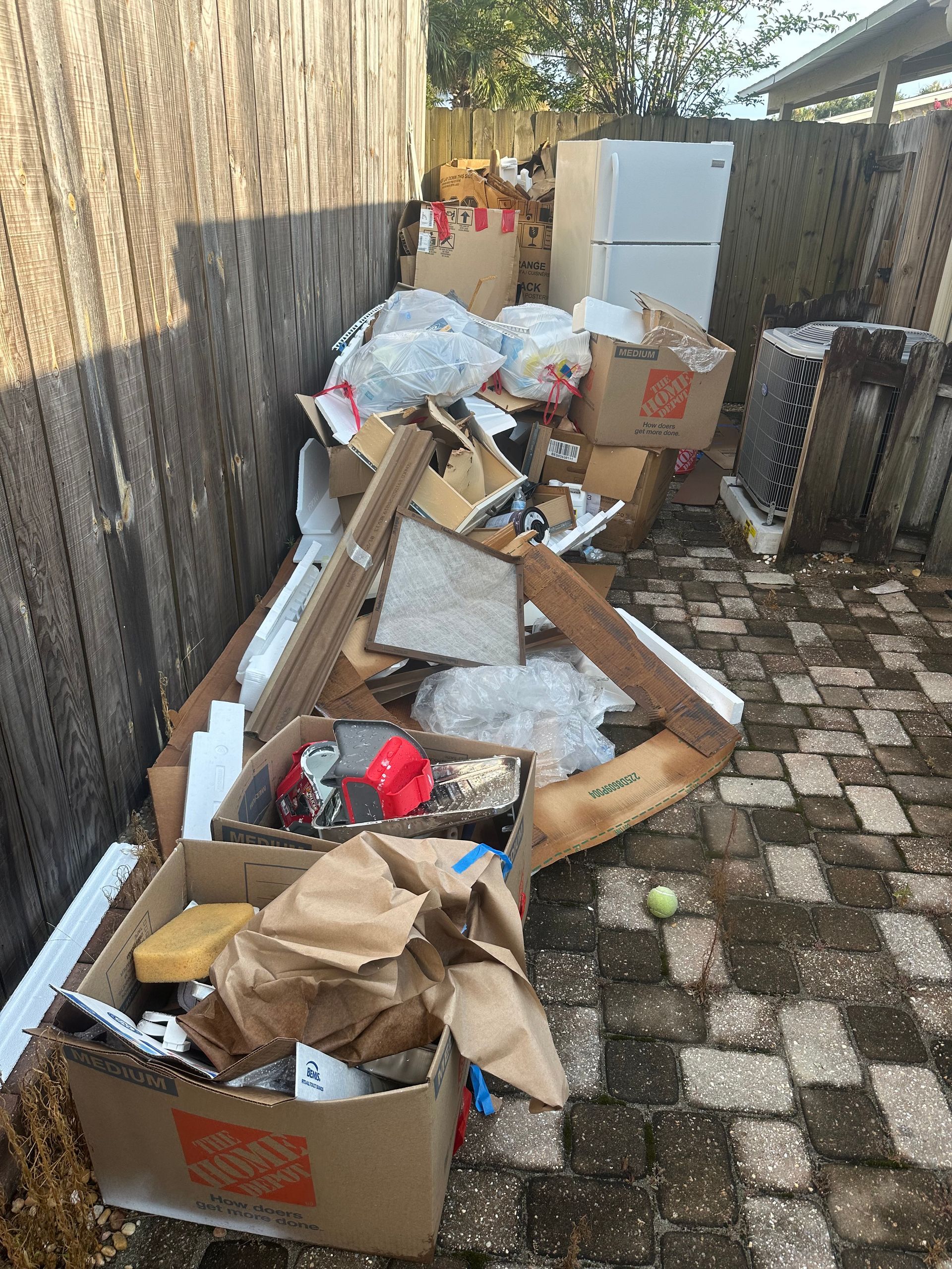 Moving boxes, packing material and household junk piled on a patio, PCS move house cleanout for Tyndall AFB families, FL