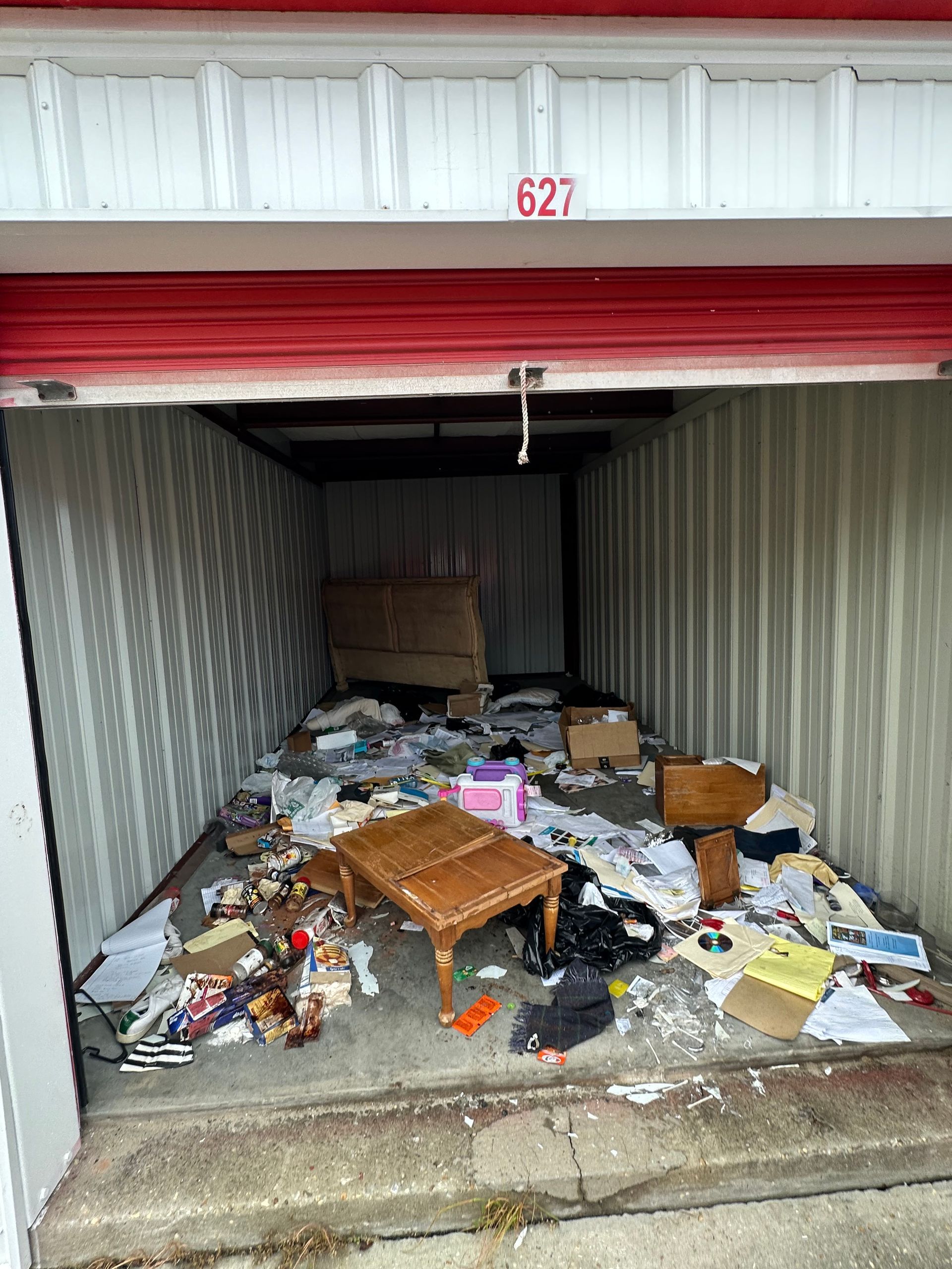 A storage unit filled with lots of trash and boxes.