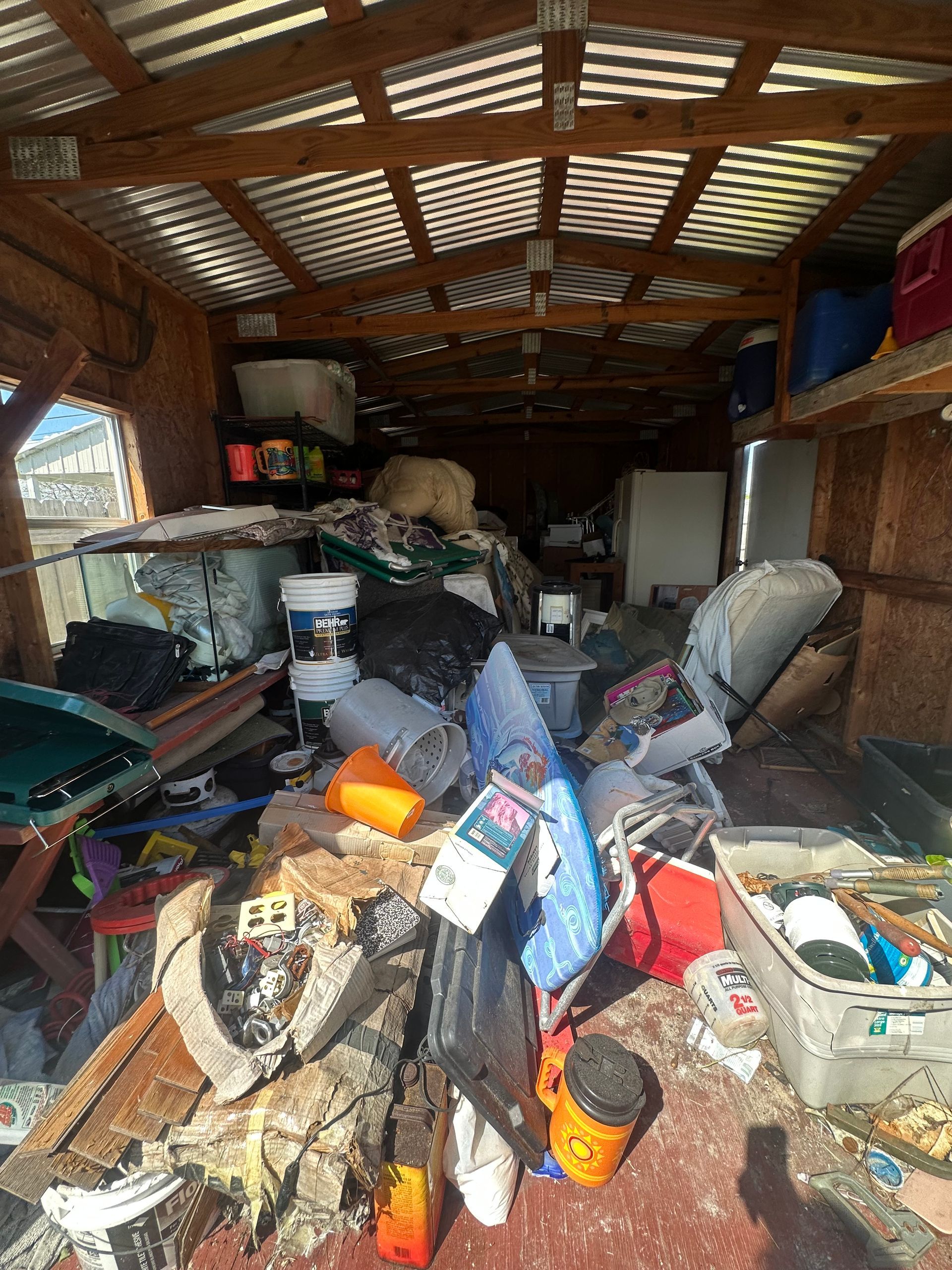 A garage filled with lots of trash and junk.