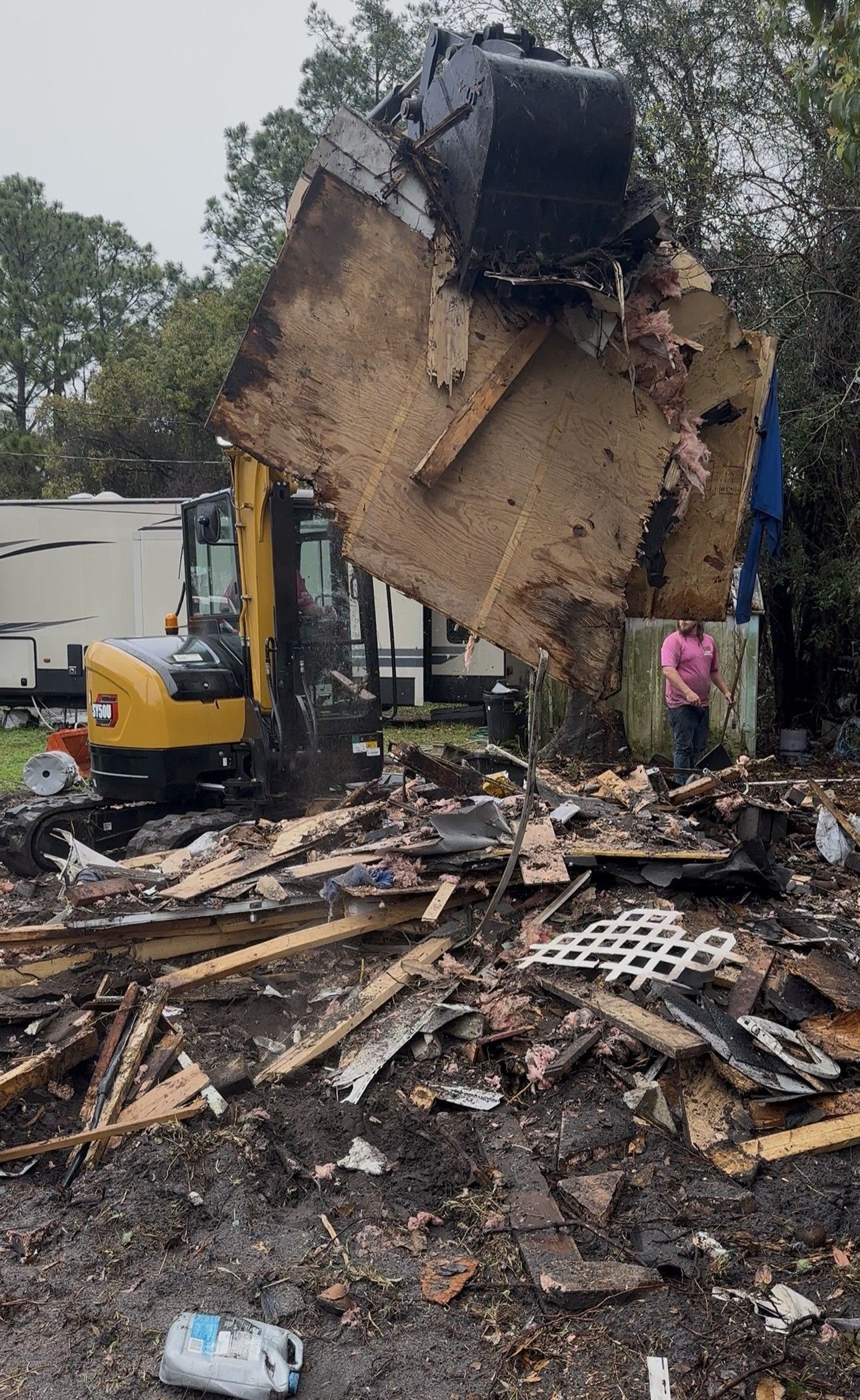 Our mini excavator lifting a load of wall and roof debris
