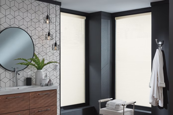 Modern bathroom with black walls, white blinds, hex tile accent wall, round mirror, and hanging towels