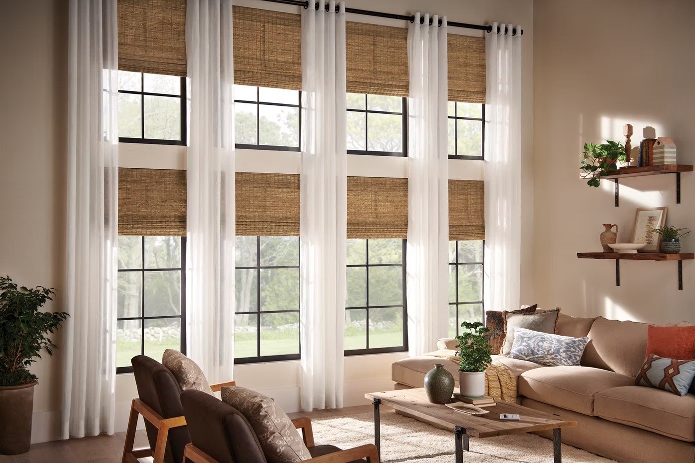 Bright living room with tall windows, woven blinds, beige sofa, plants, and a coffee table.