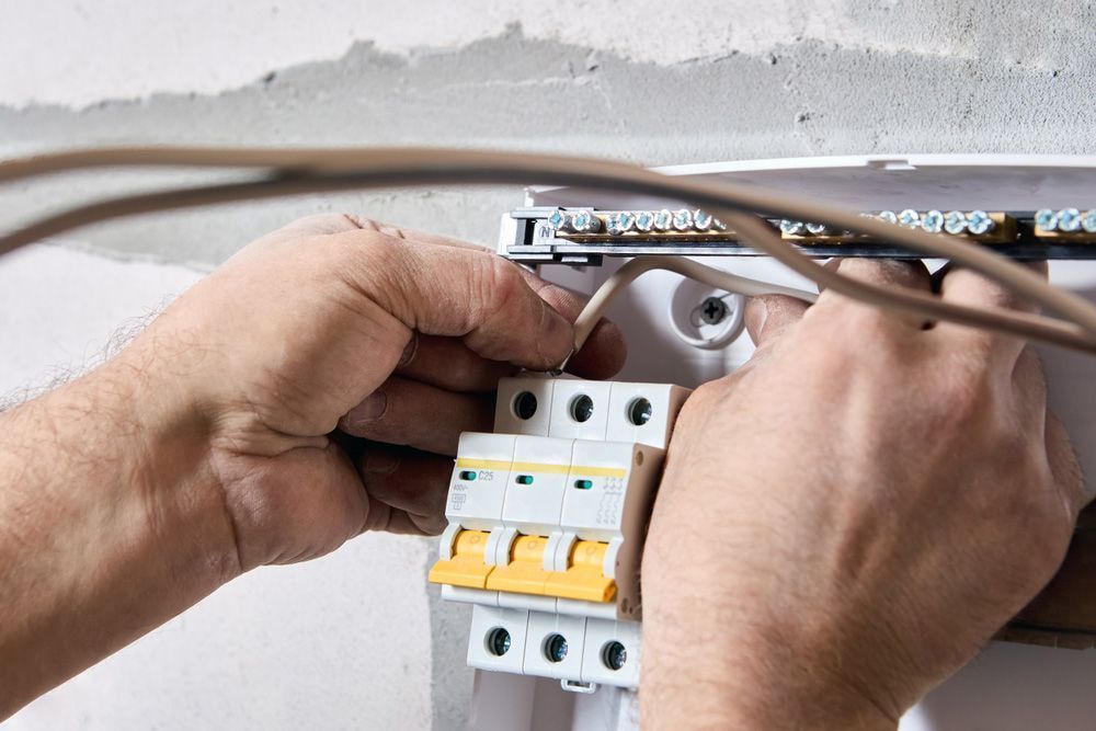 Hands Connecting a Wire to a Circuit Breaker — Active Airconz in Tennant Creek, NT