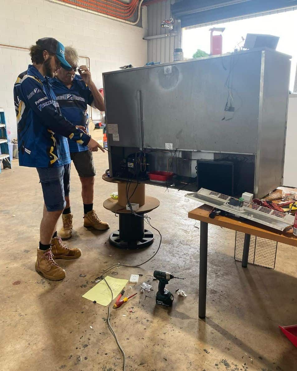 Two People Examining a Large Metal Appliance — Active Airconz in Winnellie, NT