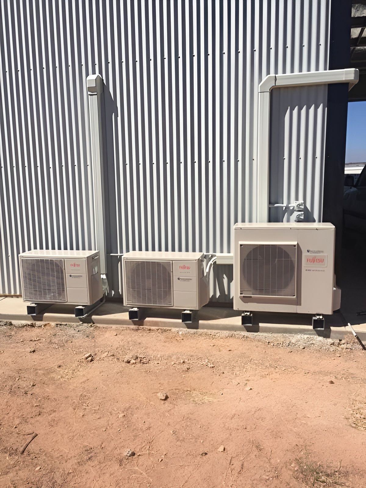 Three Beige Air Conditioning Units Outside a Corrugated Metal Building — Active Airconz in Western Australia Urban, Rural & Remote, QLD
