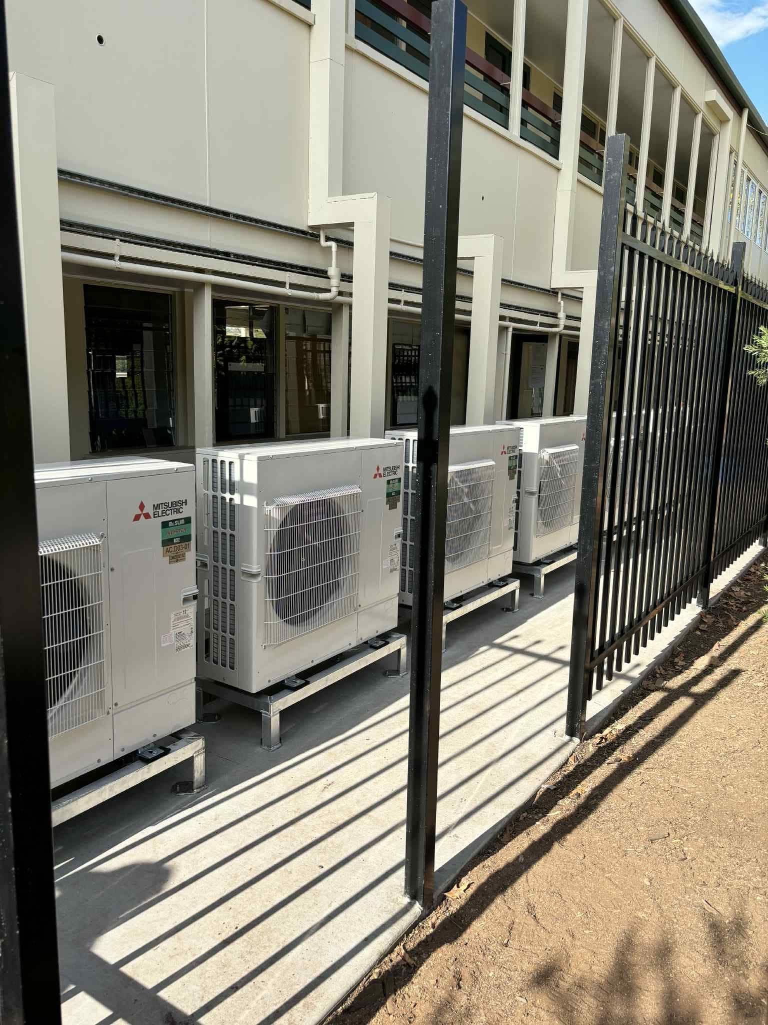 Row of White Air Conditioning Units Outside a Building — Active Airconz in Cairns, QLD