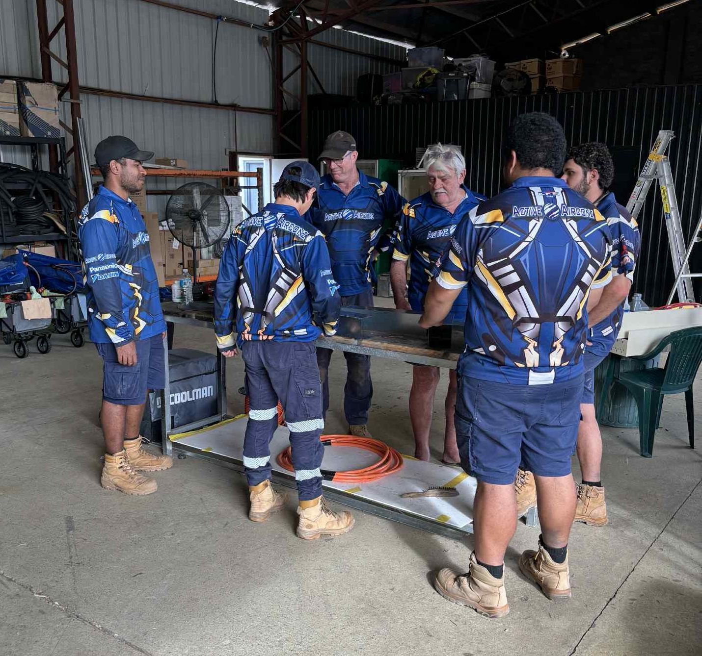 Workers In Blue Uniforms Gathered Around — Active Airconz in Winnellie, NT