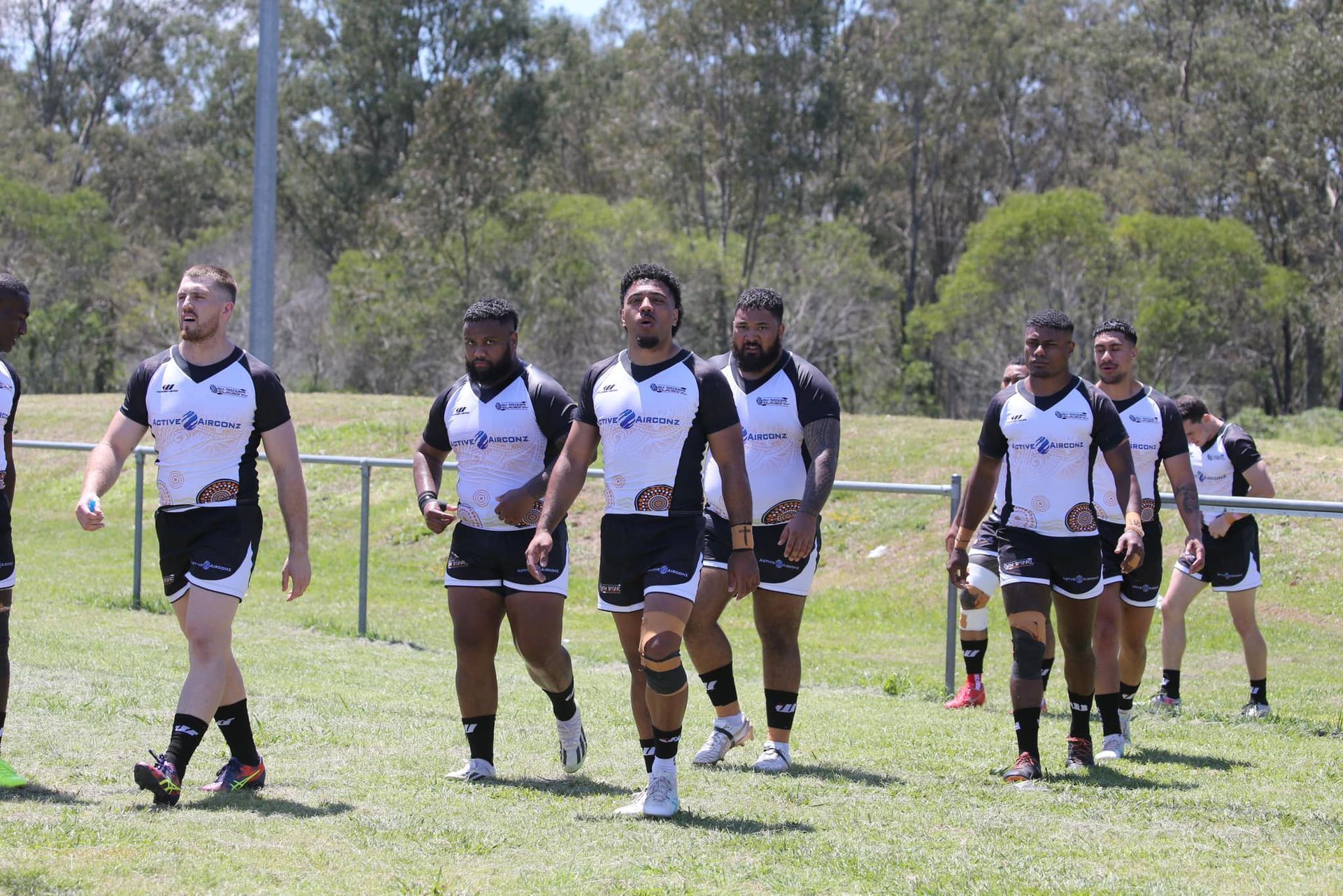 Rugby Players in Black-and-white Uniforms Walking on a Grassy Field — Active Airconz in Winnellie, NT