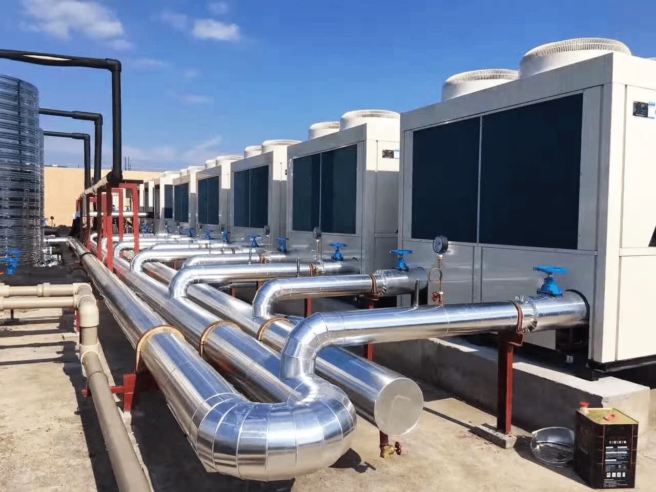 Industrial air conditioning units on a rooftop, with insulated pipes and clear sky. — Active Airconz in Gold Coast, QLD