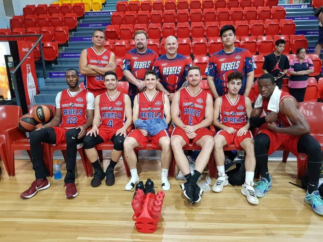 Basketball Team Posing on a Court Wearing Red Uniforms — Active Airconz in Tennant Creek, NT