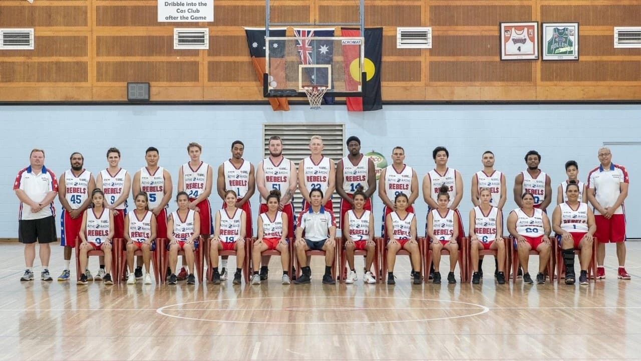 Basketball team and coaches posing in a gym after a game, wearing red and white uniforms. — Active Airconz in Winnellie, NT