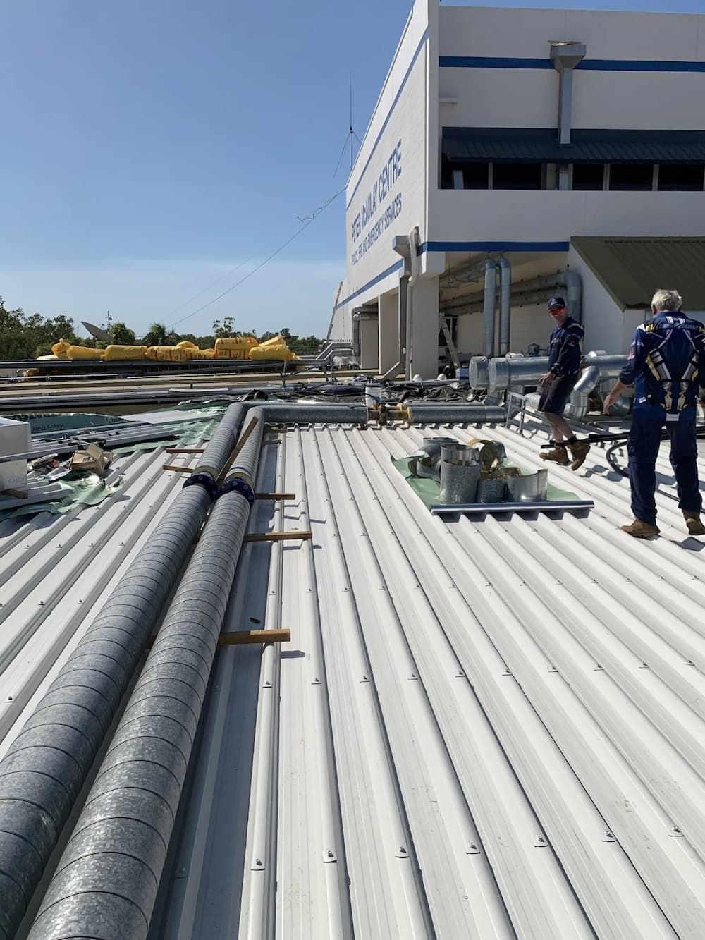Two Workers on A White Corrugated Metal Roof — Active Airconz in Perth, QLD
