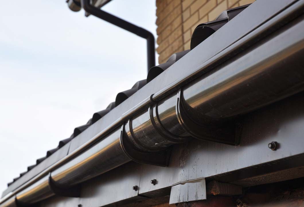 A close up of a gutter on the side of a building.