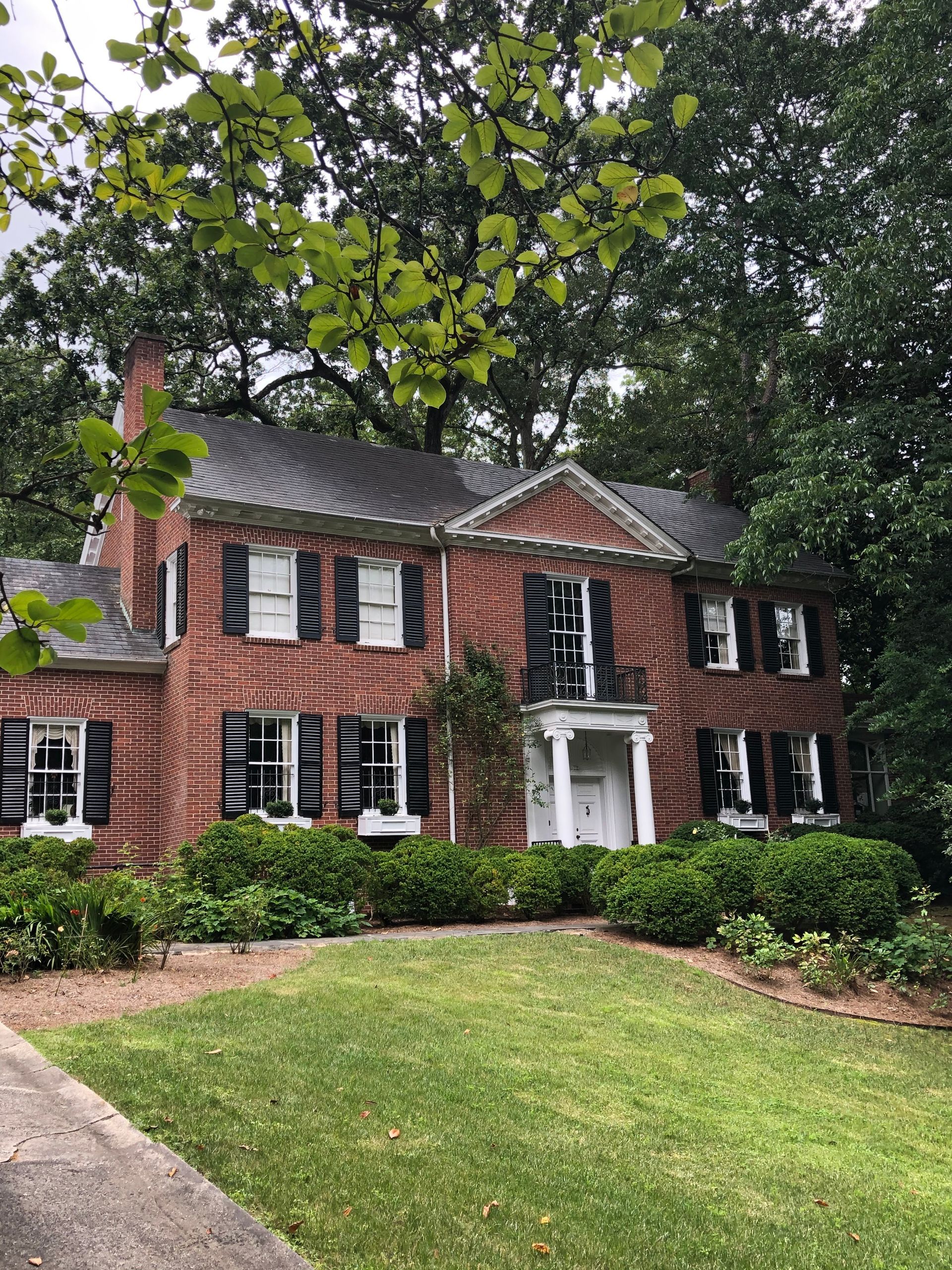 A large house with a brick chimney in front of it