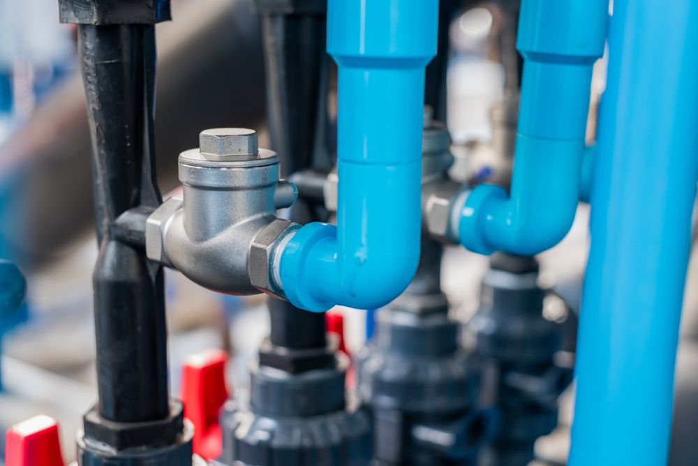 A Close Up of Blue Pipes and Valves in a Factory — T. Woods Plumbing in Bathurst, NSW