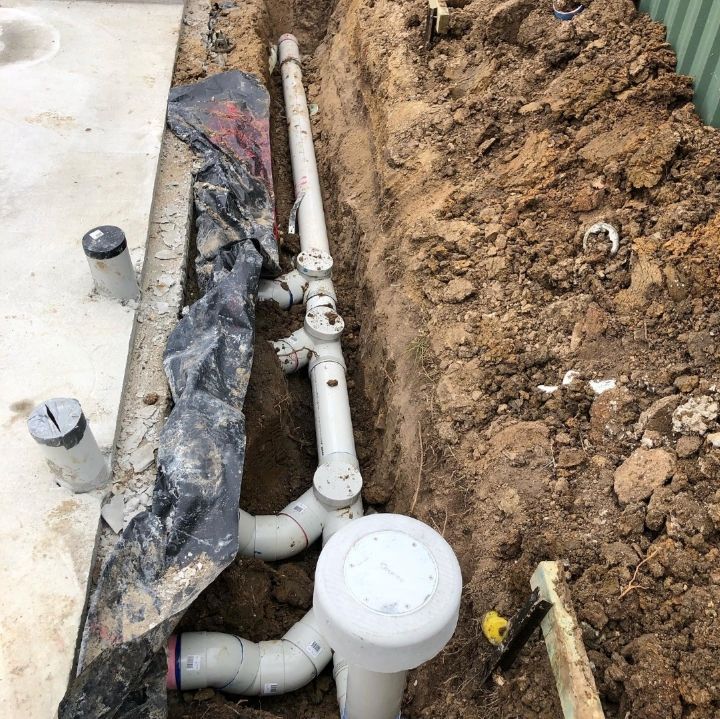 A Bunch of Pipes Are Laying in the Dirt — T. Woods Plumbing in Bathurst, NSW