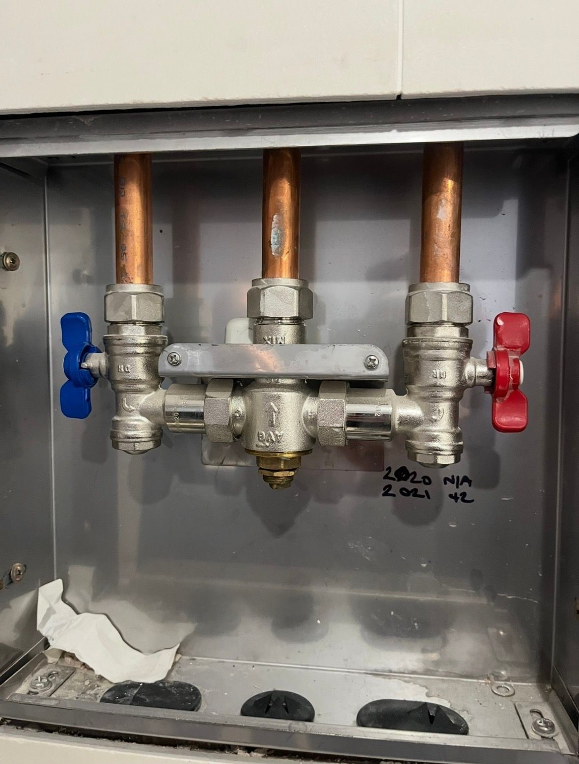 Plumbing manifold with copper pipes, blue and red valves, inside a wall access panel. — T. Woods Plumbing in Bathurst, NSW