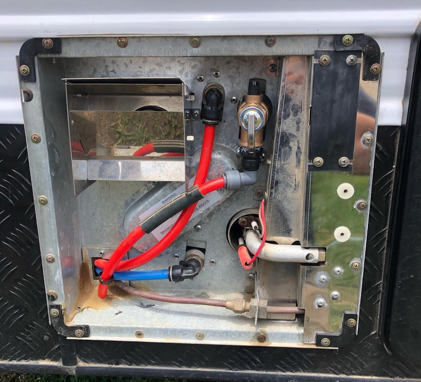 RV Water Heater Compartment With Red And Blue Water Lines