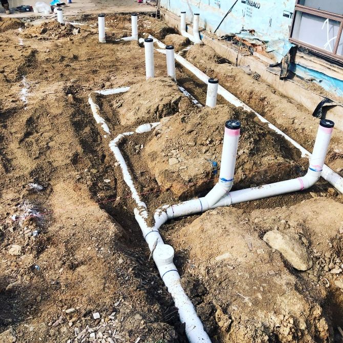 A Bunch of Pipes Are Laying in the Dirt — T. Woods Plumbing in Bathurst, NSW