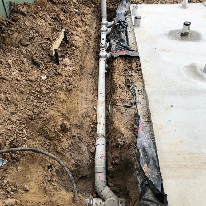 A Pipe is Being Installed in a Hole in the Ground — T. Woods Plumbing in Bathurst, NSW