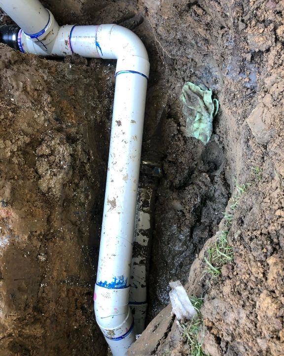 A White Pipe is Laying in the Dirt — T. Woods Plumbing in Bathurst, NSW