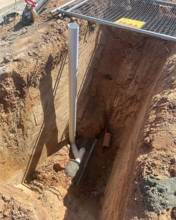 A Pipe is Being Installed in a Hole in the Ground — T. Woods Plumbing in Bathurst, NSW