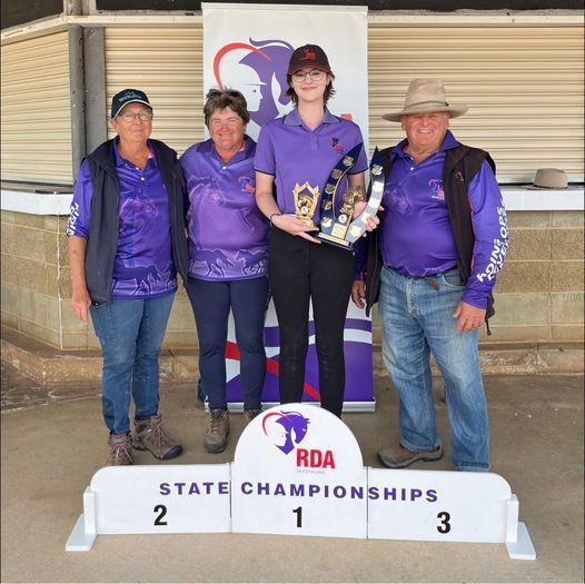 People holding trophies at RDA State Championships, standing on a podium.