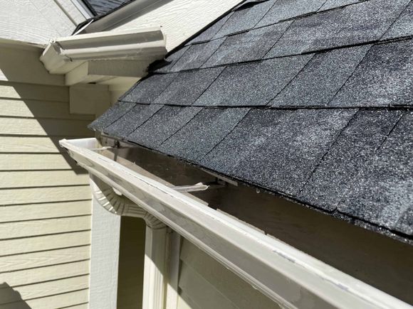 A close up of a gutter on a roof of a house.