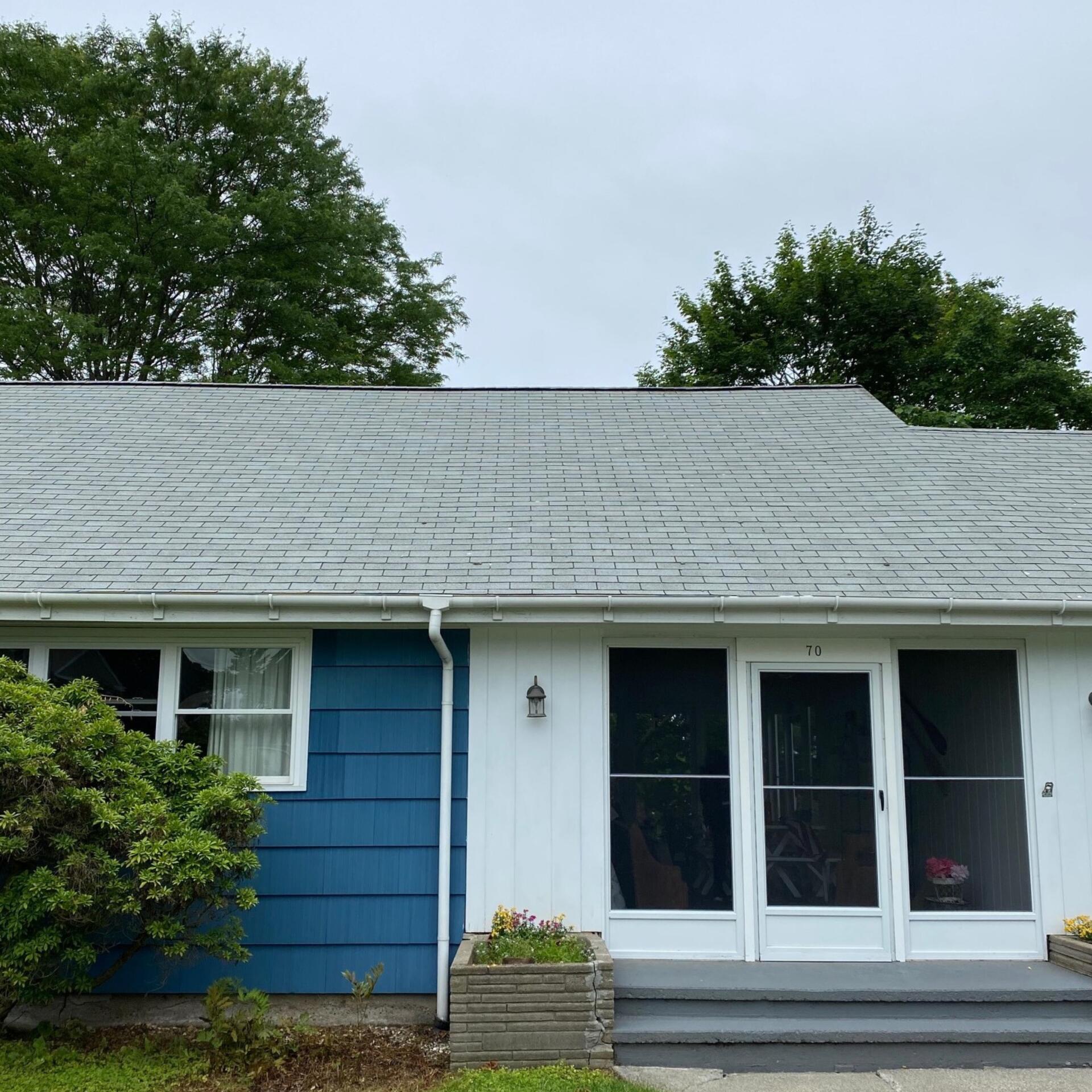 A blue and white house with a gray roof