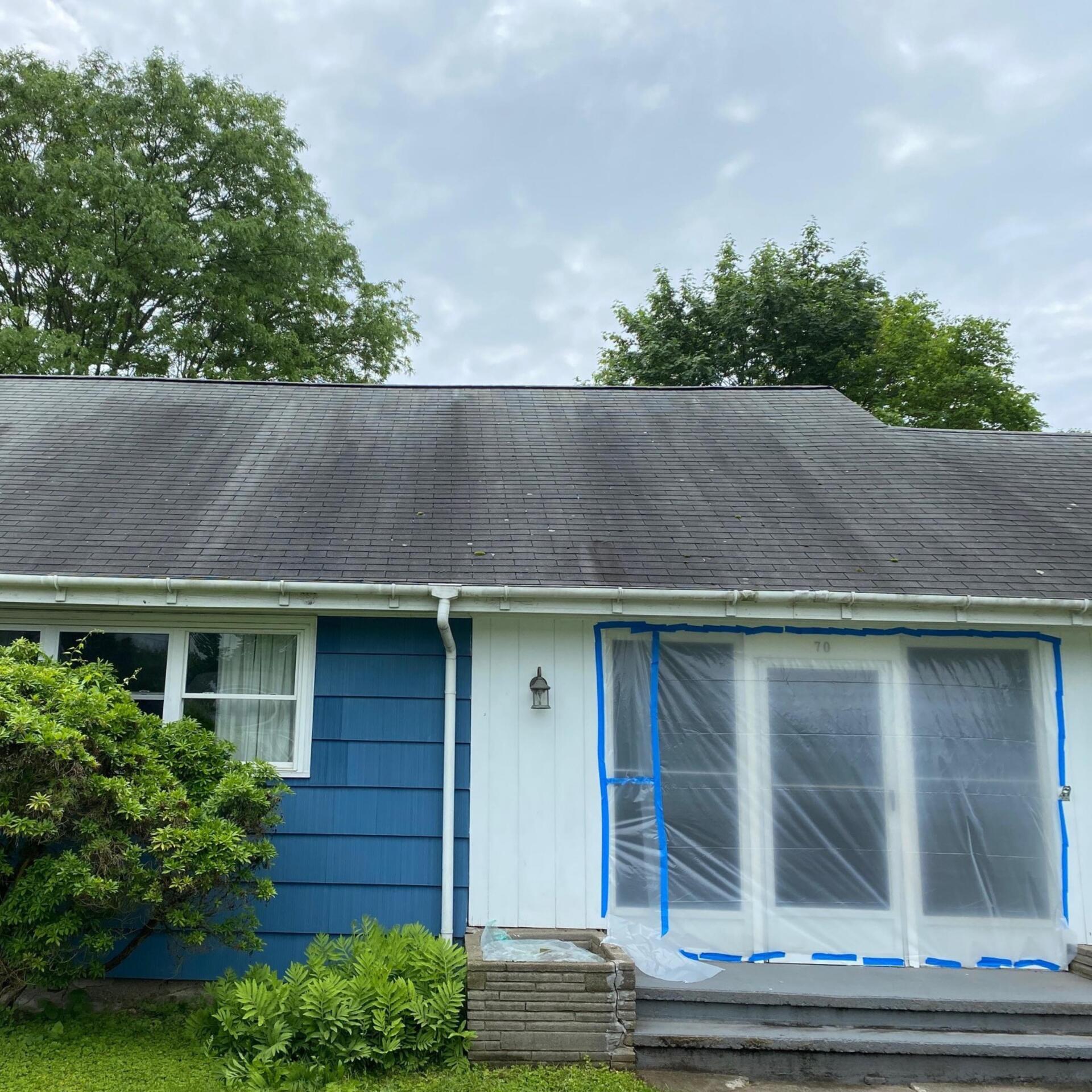 A blue and white house with a black roof