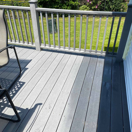 A wooden deck with a chair and a railing