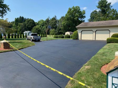 A truck is parked in a driveway next to a house.