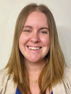 A woman wearing glasses and a white shirt is smiling for the camera.