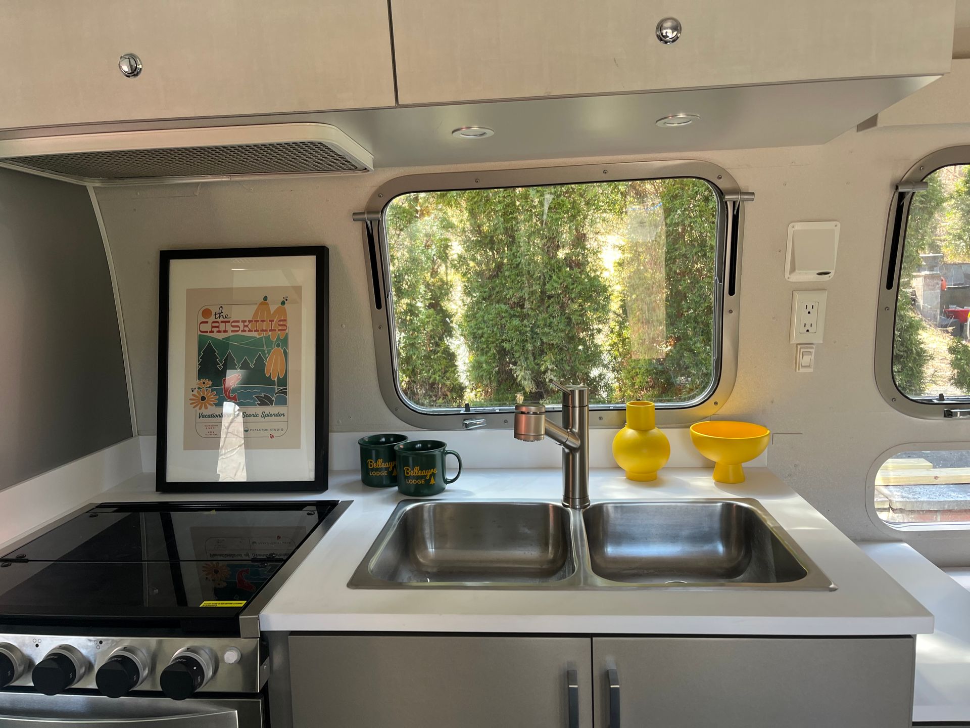 Fully-equipped kitchen with sink, range stove and over, views of Catskills outside the window.