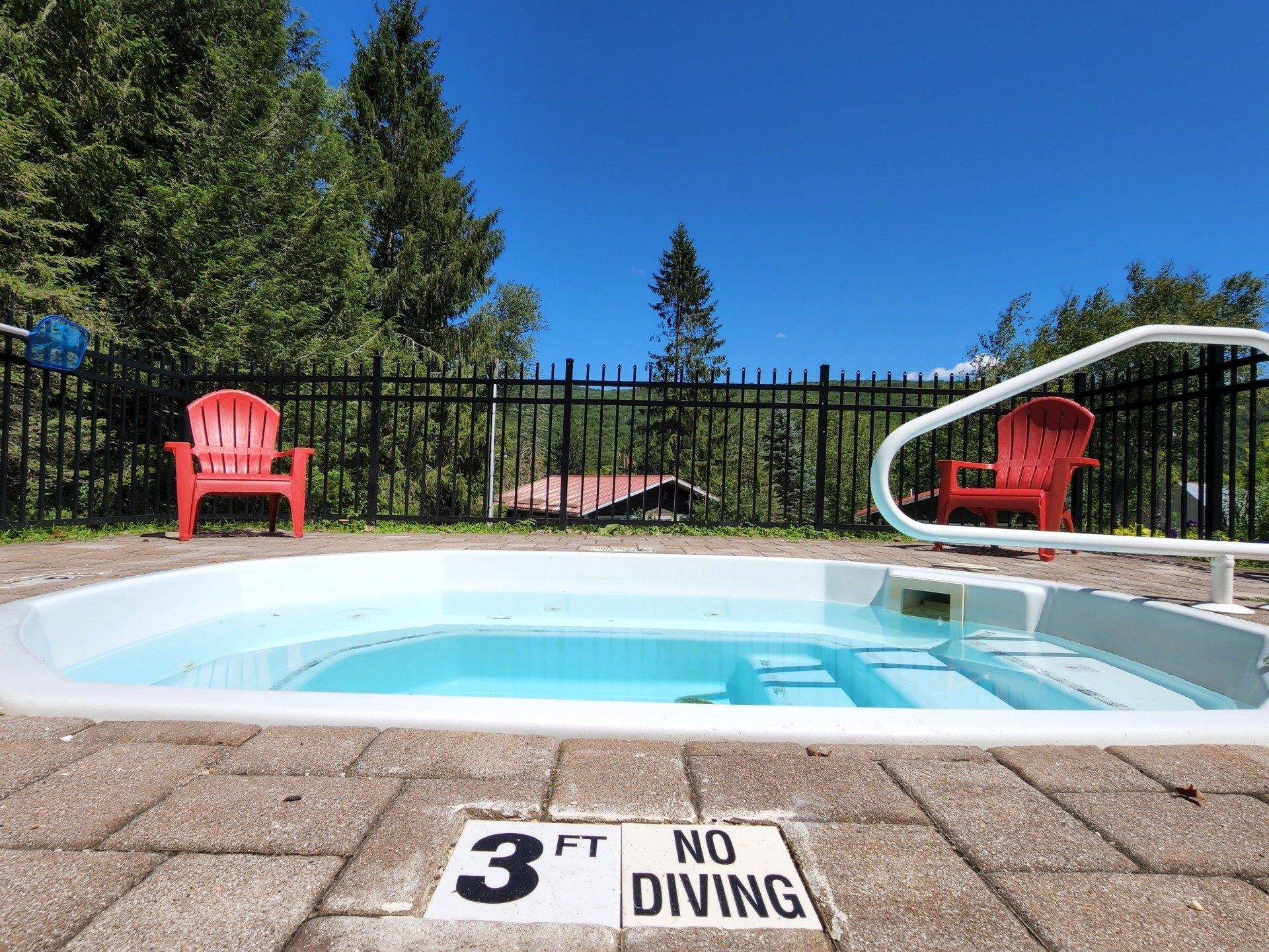 Saltwater Pool at Belleayre Lodge in Pine Hill, with red chairs in the background against black fence.