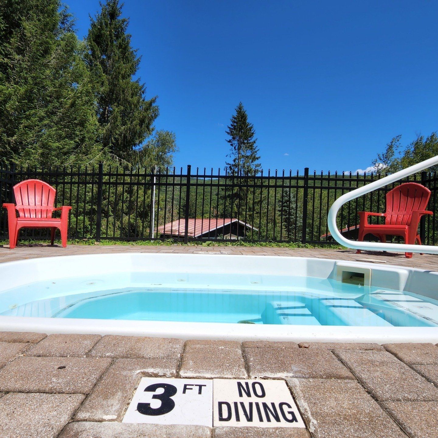 Saltwater Pool at Belleayre Lodge in Pine Hill, with red chairs in the background against black fence.