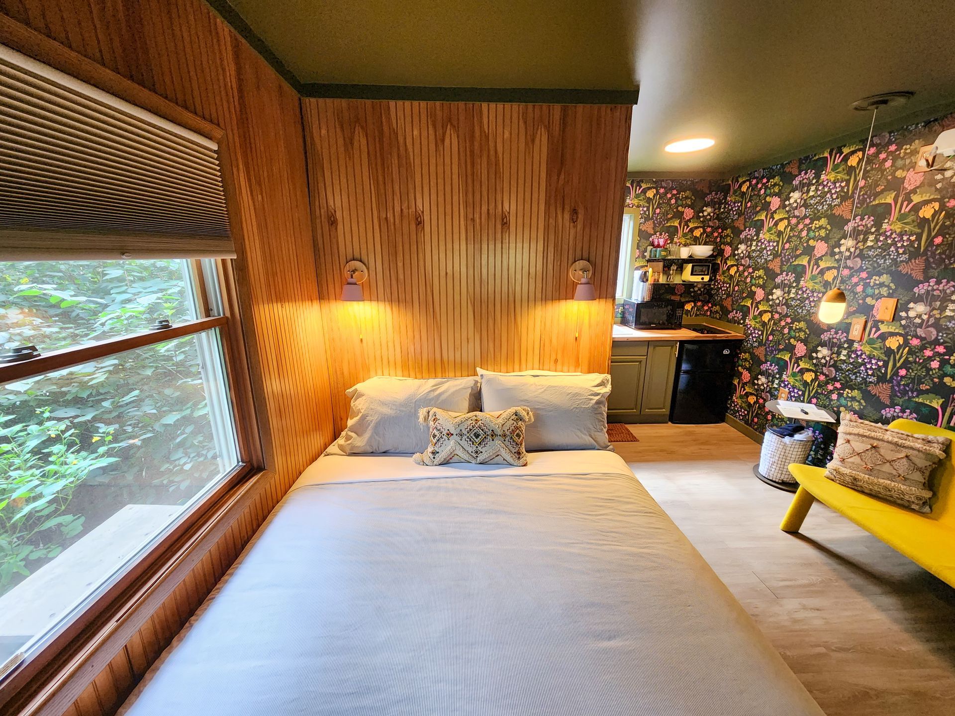 Cozy interior of a Belleayre Lodge hotel-style cabin, showing bed, beautiful Catskills views out the window, and sofa.
