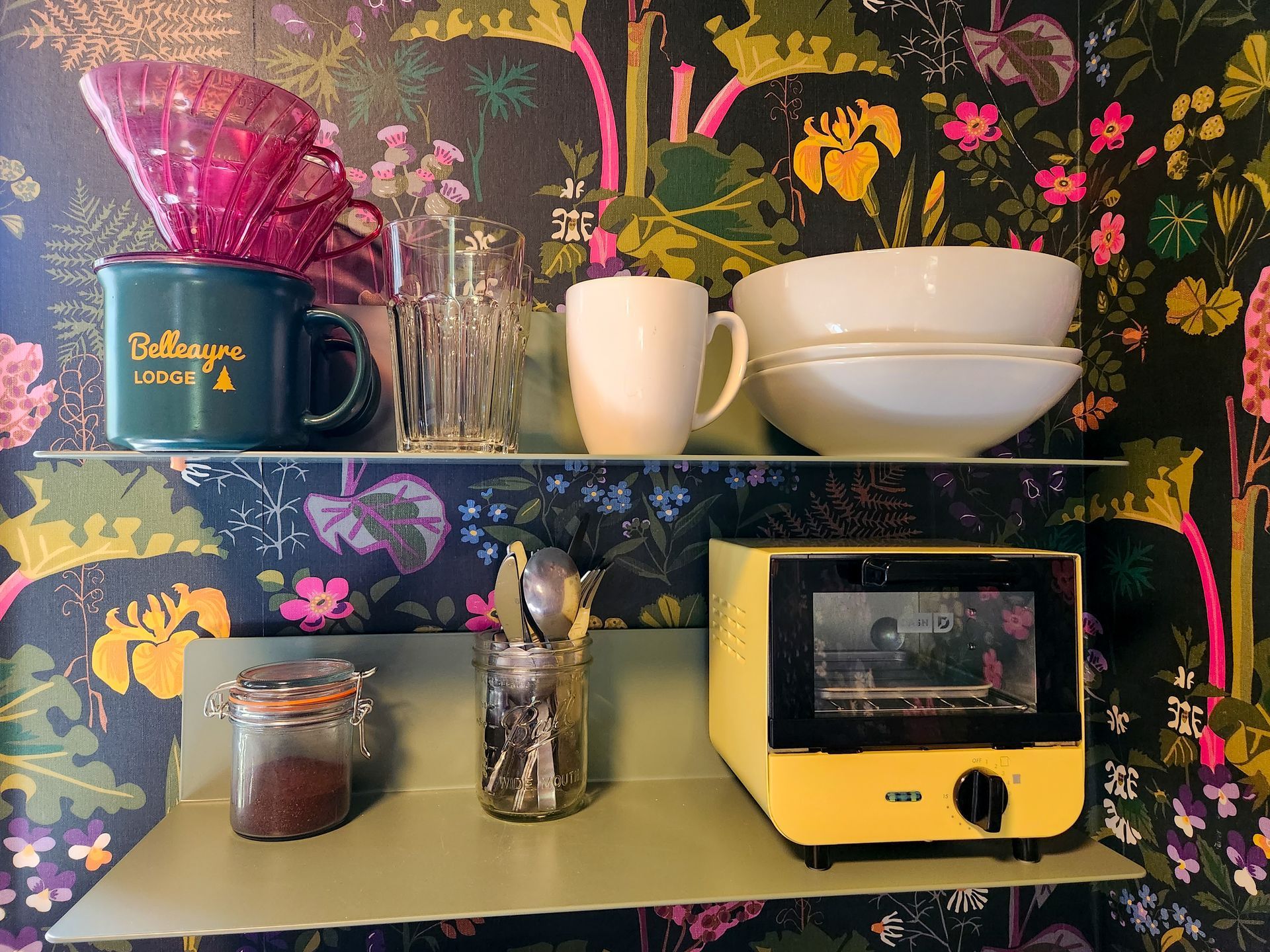 Kitchen area of Belleayre Lodge Cabin #2, showing small kitchen appliances, vibrant floral wallpaper.
