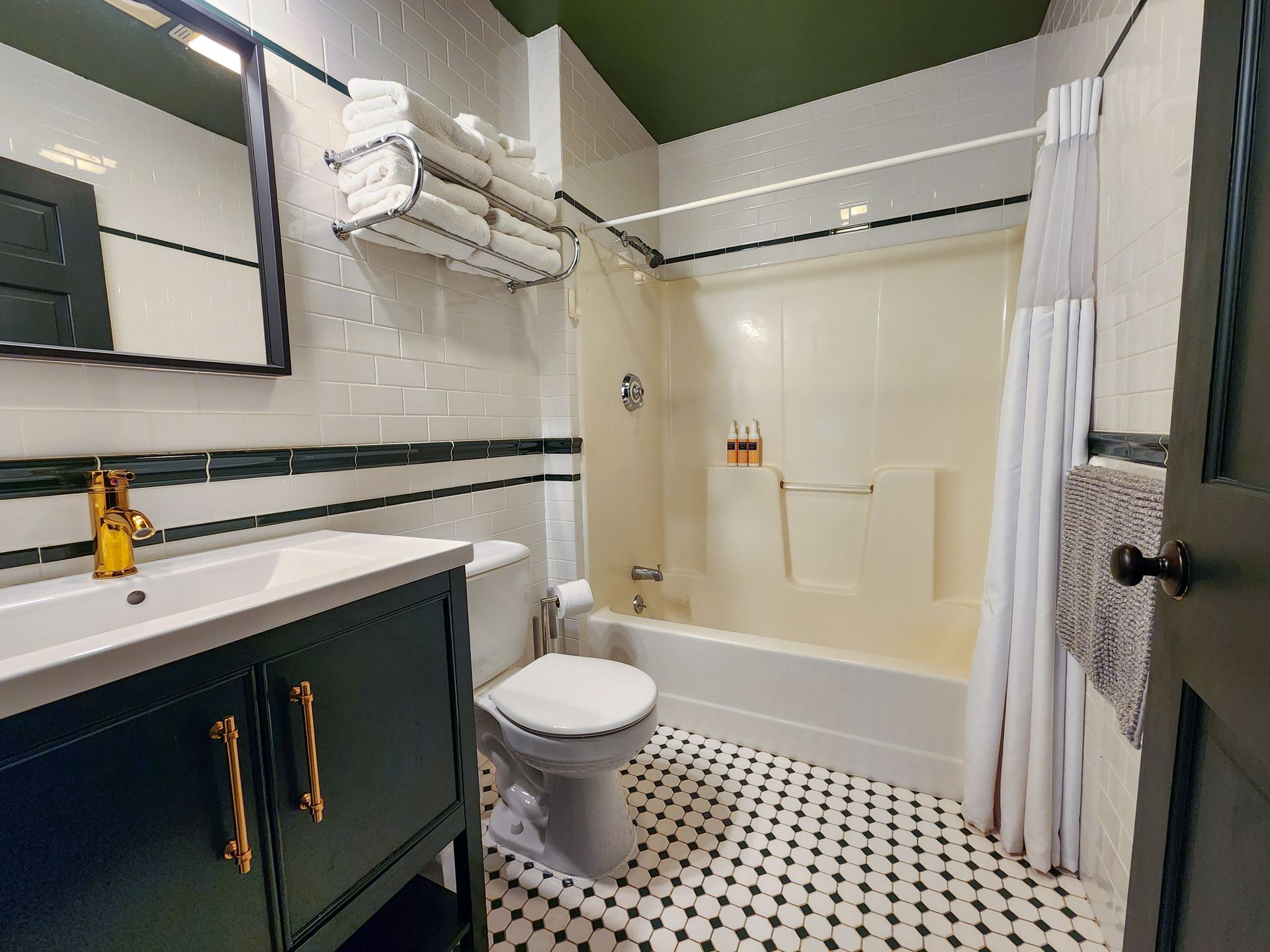 Bathroom of Cabin #4A at Belleayre Lodge, showing polka dot tiled floors, spacious sink counter, and bath tub.