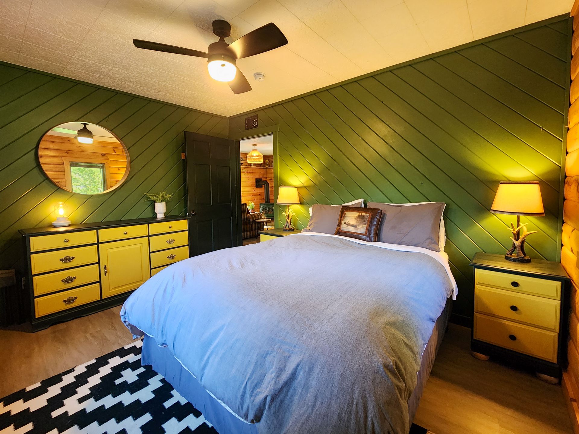 Bedroom of Cabin 4A at Belleayre Lodge, showing cozy bed, beautiful dressers and nightstands, and stylist mirrors.