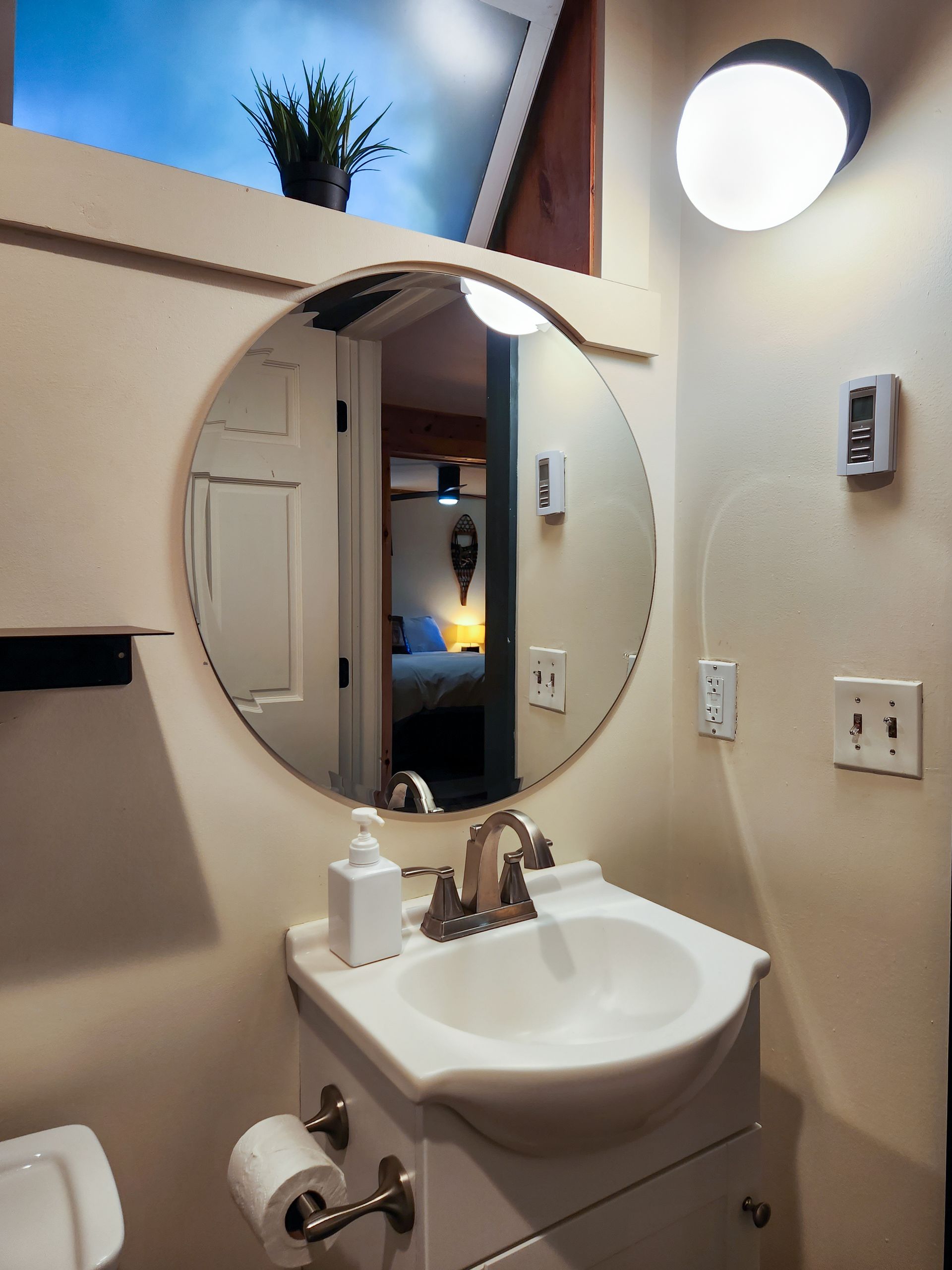 Bathroom of Cabin #4B at Belleayre Lodge, closeup of circular mirror over sink.