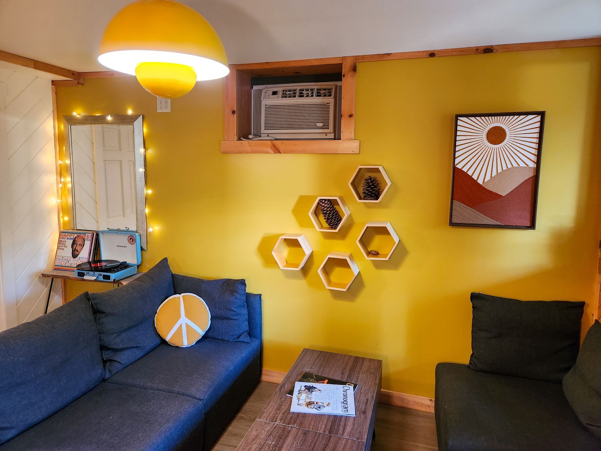 Cozy Living room of Belleayre Lodge Cabin #4B, showing yellow walls, stylish wall decor, and soft sofas.