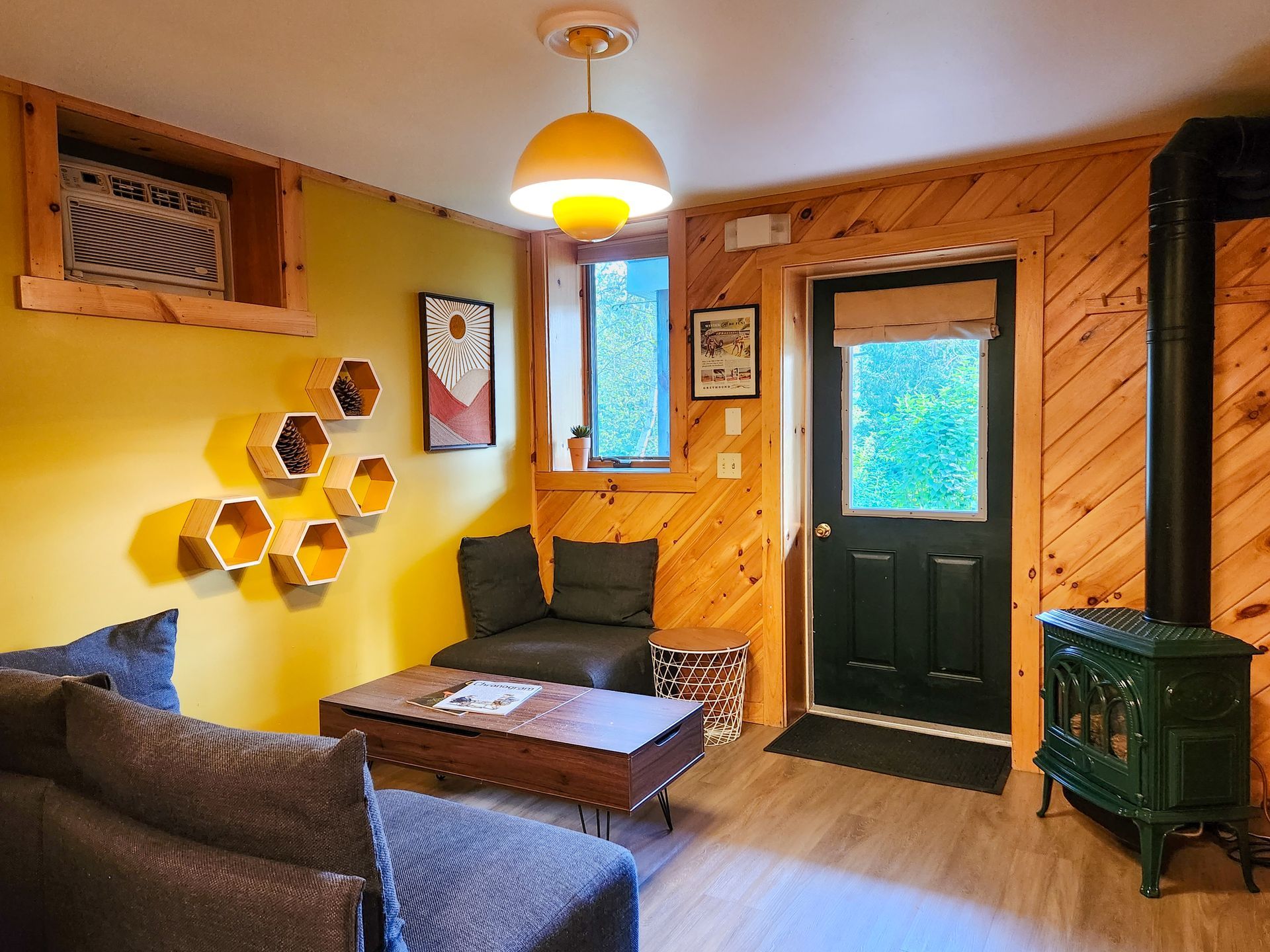 Cozy Living room of Belleayre Lodge Cabin #4B, showing yellow walls, stylish wall decor, and soft sofas.