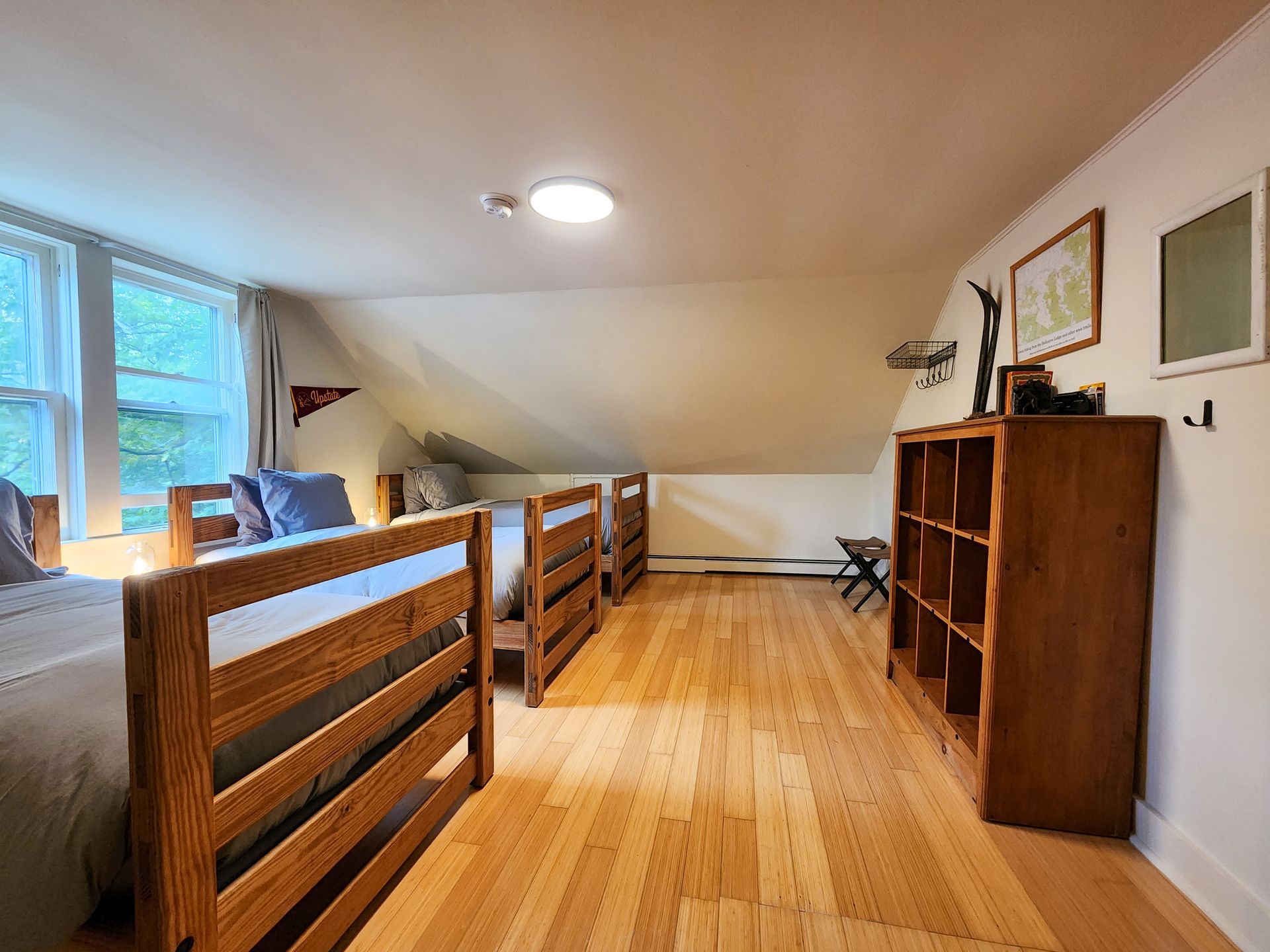 Cozy bedroom at Belleayre Lodge's Cabin #9, showing 4 twin beds and beautiful views out the window.