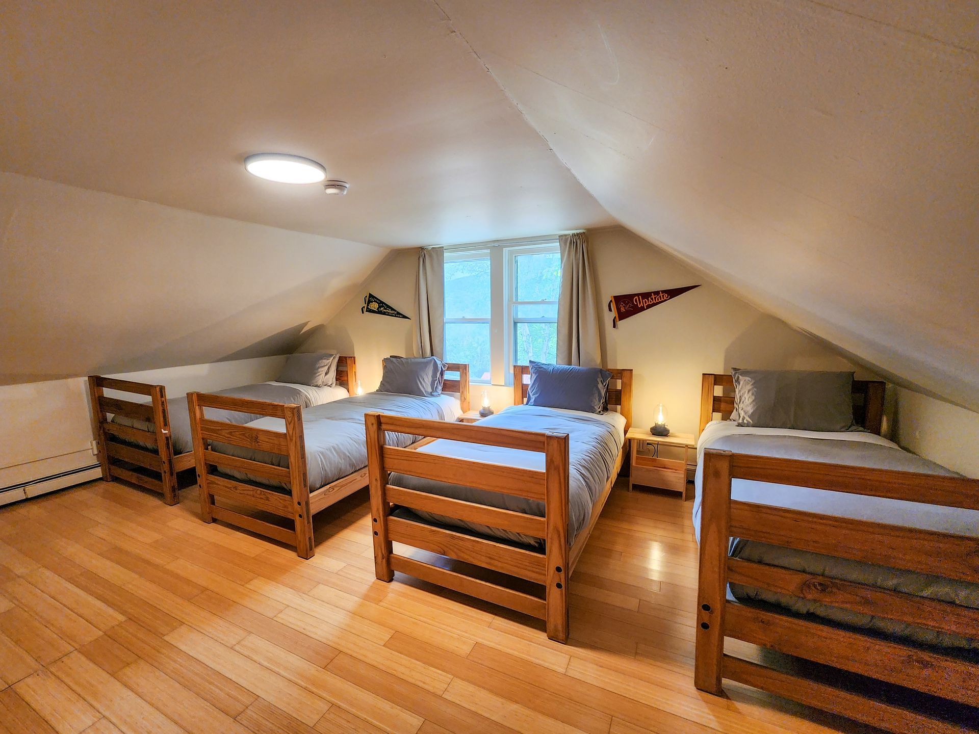 Cozy bedroom at Belleayre Lodge's Cabin #9, showing 4 twin beds and beautiful views out the window.
