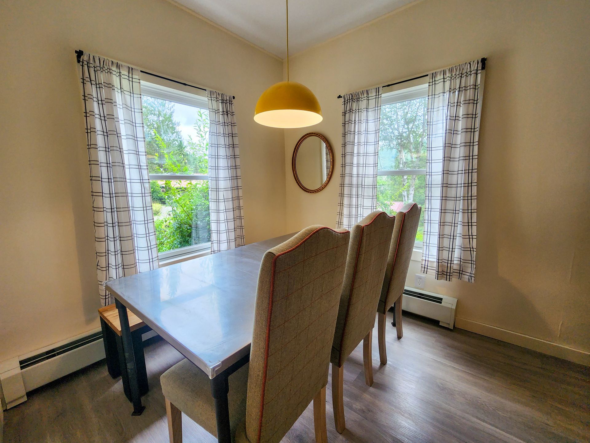 Dining area of Cabin #9 at Belleayre Lodge, showing table and chairs, plus beautiful Catskills views out window.